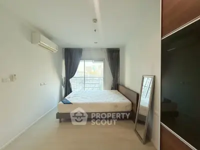 Spacious bedroom with large window and modern decor in a stylish apartment.