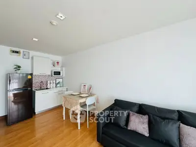 Modern living room with compact kitchen and cozy seating area, perfect for urban living.