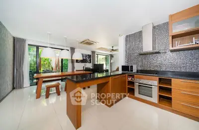 Spacious modern kitchen with open layout and sleek design, featuring a dining area and large windows.