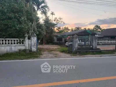Charming countryside property with lush greenery and rustic entrance gate, perfect for serene living.