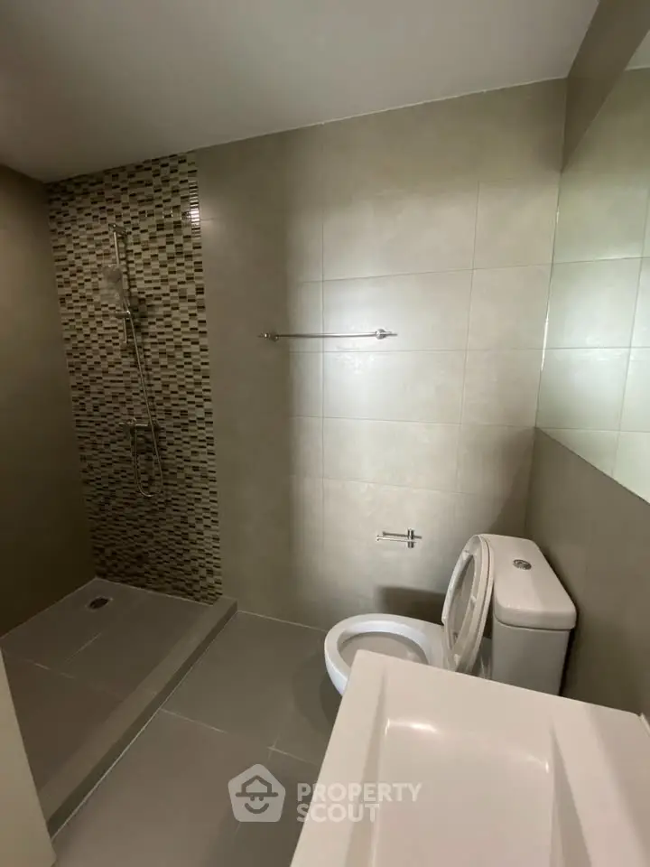 Modern bathroom with sleek shower and neutral tiles