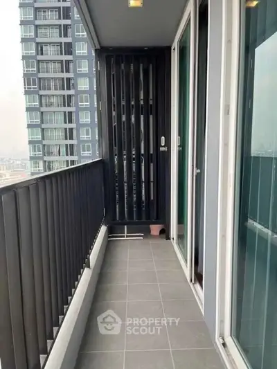 Modern high-rise apartment balcony with city view and sleek railing design.