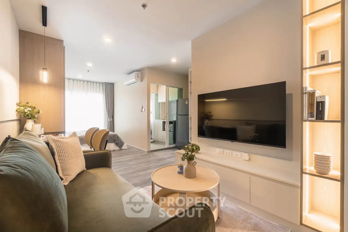 Modern living room with stylish decor and open layout, featuring a cozy sofa and wall-mounted TV.