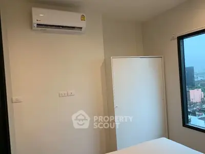 Minimalist bedroom with air conditioning and city view window