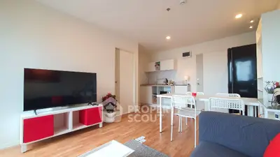 Modern living room with open kitchen, stylish furniture, and wooden flooring