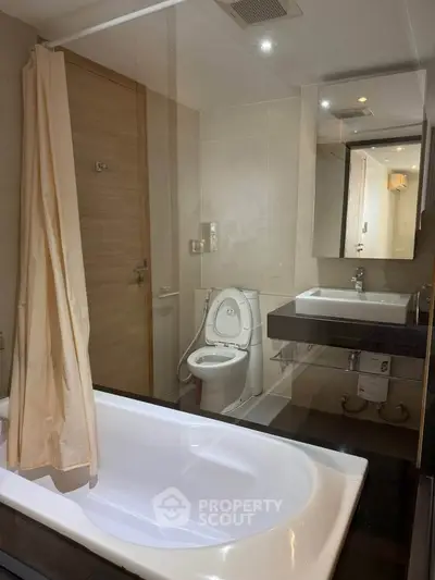 Modern bathroom with bathtub and sleek fixtures in a contemporary apartment.
