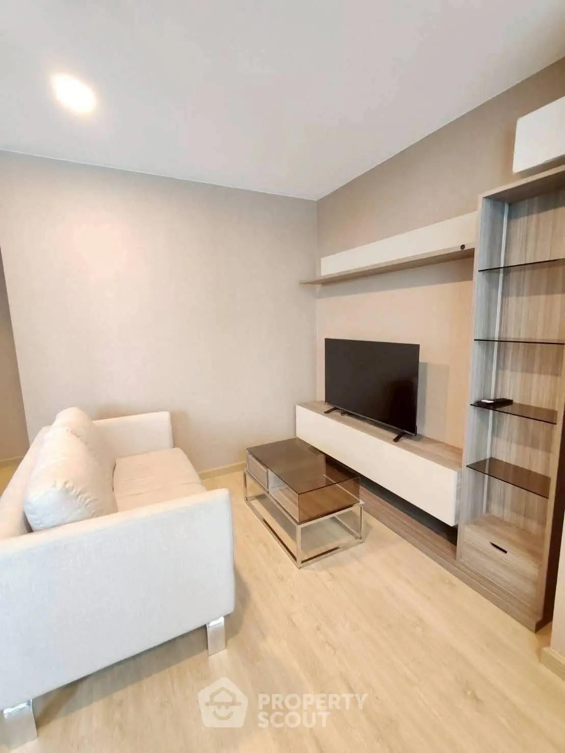 Modern living room with sleek furniture and mounted TV, perfect for relaxation and entertainment.