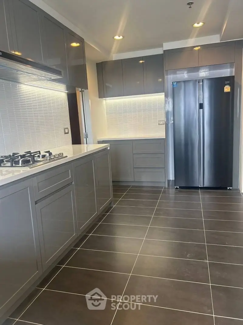 Modern kitchen with sleek cabinetry and stainless steel appliances in a contemporary apartment.