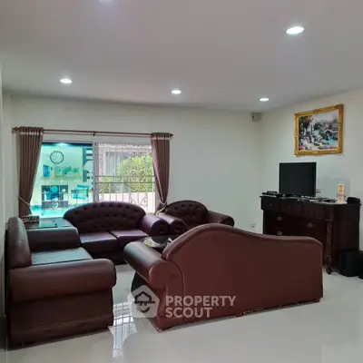 Spacious living room with elegant leather sofas and large window view