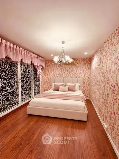 Elegant bedroom with floral wallpaper and plush bed in cozy real estate listing.