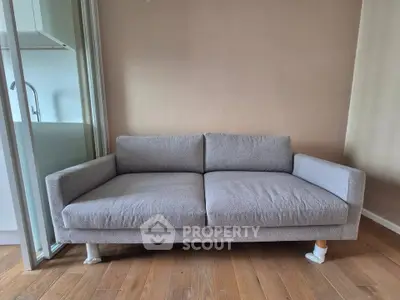 Modern living room with stylish gray sofa and wooden flooring