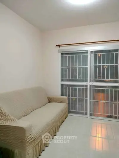 Cozy living room with a comfortable sofa and large window for natural light.