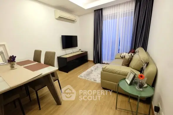 Modern living room with cozy sofa, dining area, and wall-mounted TV in a stylish apartment.