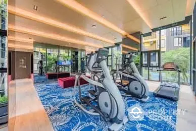 Modern gym with state-of-the-art equipment and large windows overlooking greenery.