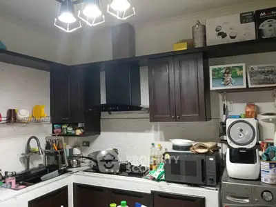 Modern kitchen with sleek cabinets and appliances, featuring a gas stove and microwave.