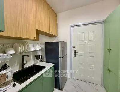 Charming kitchen with modern appliances and sleek cabinetry in a cozy apartment.