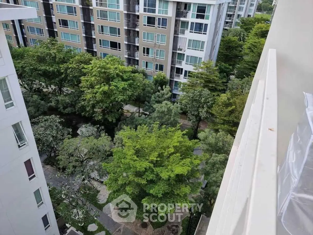 High-rise residential buildings with lush green garden view from balcony.