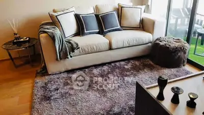 Cozy living room with plush sofa, stylish decor, and natural light.