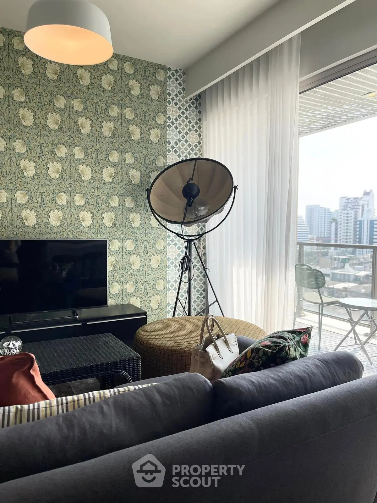 Stylish living room with modern decor and city view balcony, perfect for urban living.