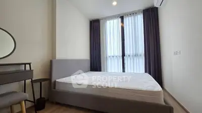 Modern bedroom with large window and minimalist decor in a stylish apartment.
