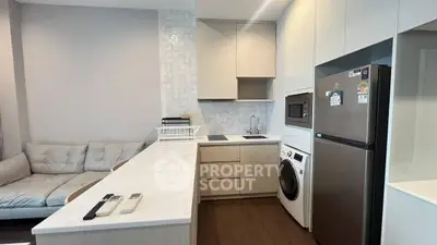 Modern kitchen with sleek appliances and cozy living area, perfect for urban living.