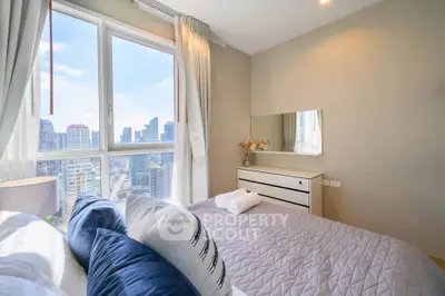 Bright bedroom with city view, modern decor, and large window for natural light.