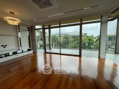 Spacious living room with large windows and balcony view in luxury home.