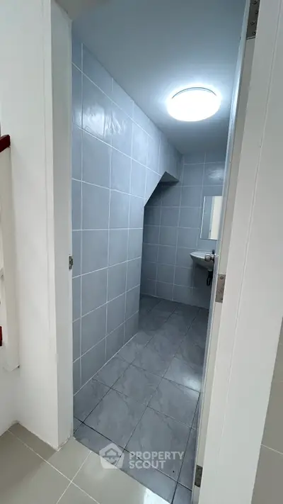 Modern minimalist bathroom with sleek gray tiles and compact design