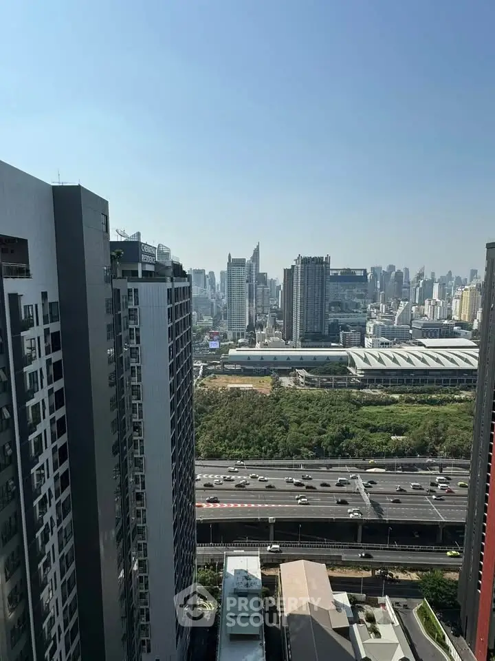 Stunning cityscape view from high-rise building overlooking urban skyline and highway.