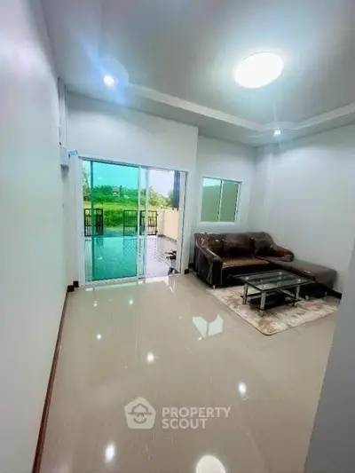 Spacious living room with modern furniture and access to a large balcony with scenic views.