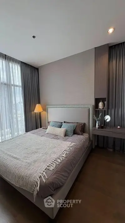 Luxurious bedroom with elegant decor and large windows offering natural light.
