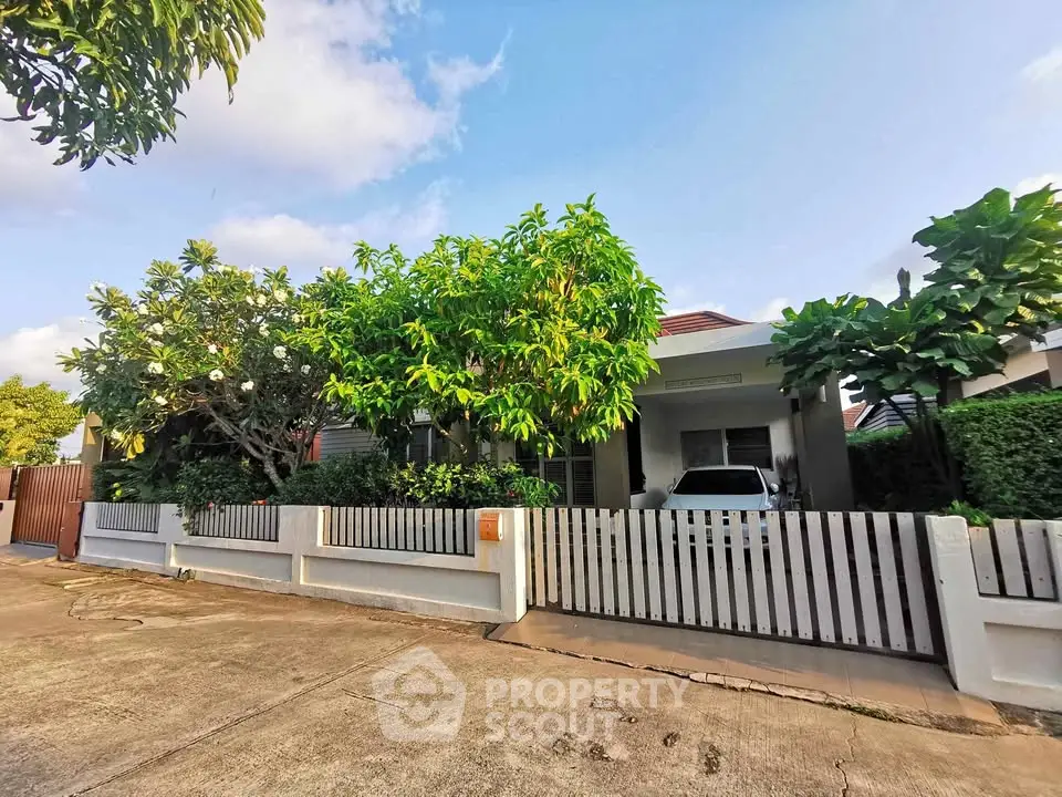 Charming suburban home with lush greenery and spacious driveway, perfect for family living.