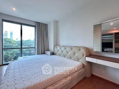 Spacious bedroom with large window offering stunning city views and modern furnishings.