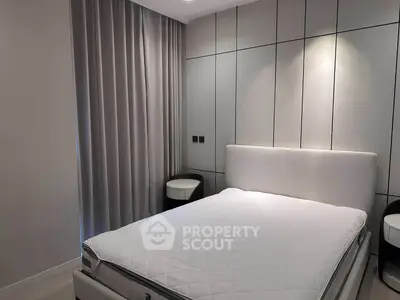 Modern bedroom with sleek design and elegant furnishings, featuring a comfortable bed and stylish side tables.