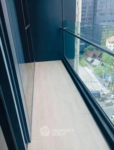 Modern balcony with glass railing and city view, perfect for urban living.