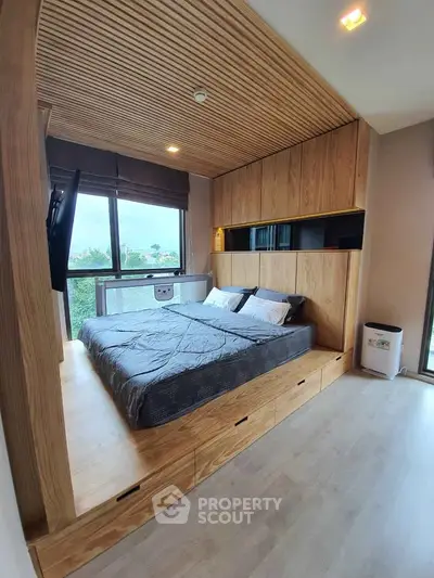 Modern bedroom with wooden accents and large window offering scenic views