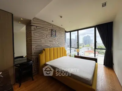 Modern bedroom with large window offering city view, stylish decor, and comfortable bed.