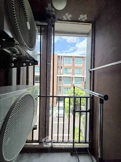 Compact balcony with laundry appliances and view of modern building exterior.