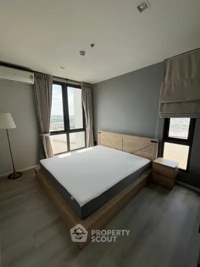 Modern bedroom with large windows and city view, featuring minimalist design and natural light.