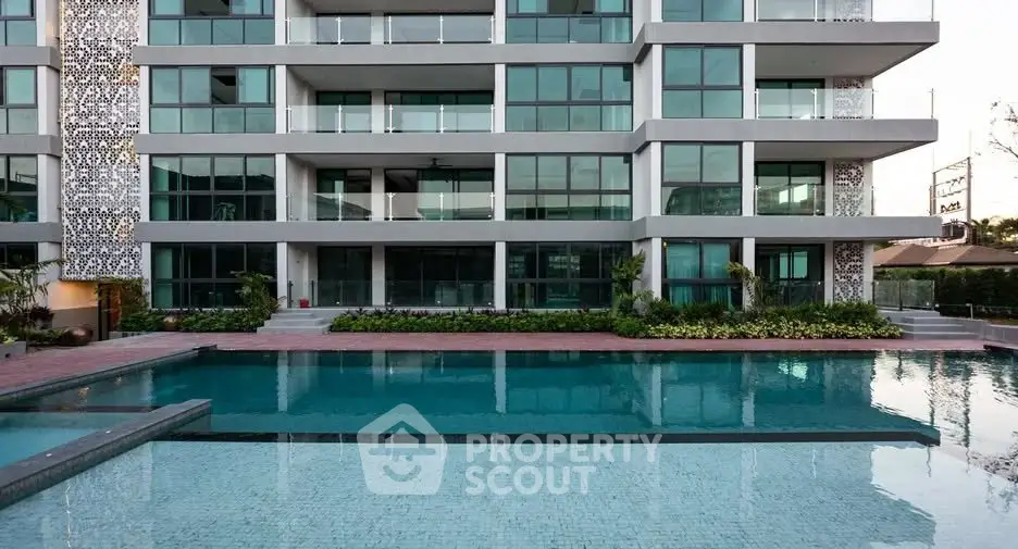 Modern apartment building with luxurious pool and stylish facade, perfect for upscale living.