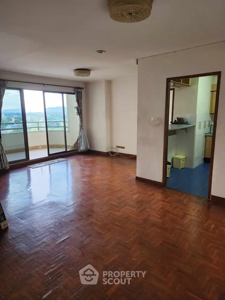 Spacious living room with wooden flooring and balcony view