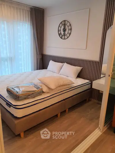 Modern bedroom with stylish decor and natural light in a cozy apartment.