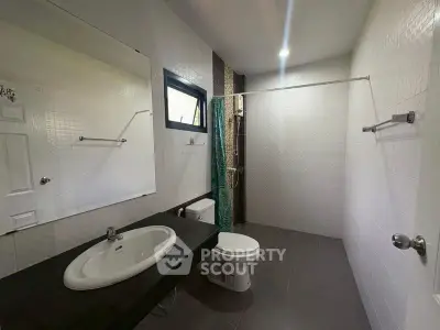 Spacious modern bathroom with sleek fixtures and ample natural light.