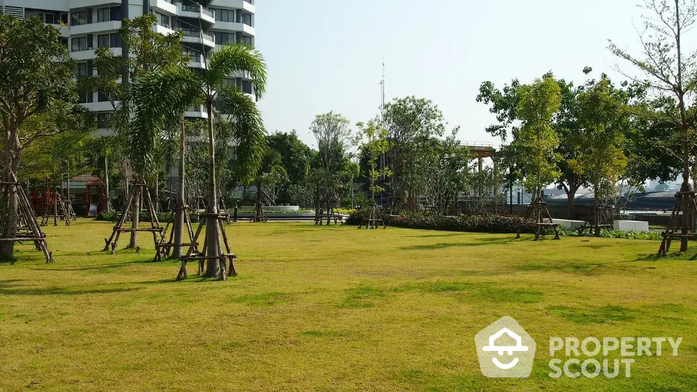 Spacious garden area with lush greenery and modern building backdrop