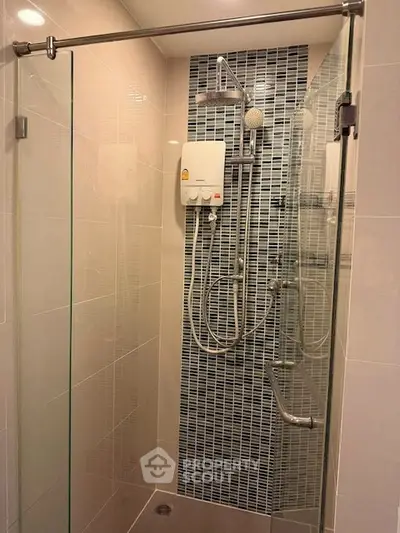 Modern bathroom with glass shower enclosure and stylish tile design.