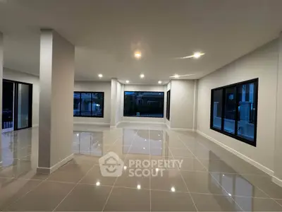 Spacious modern living room with large windows and glossy tiled floors