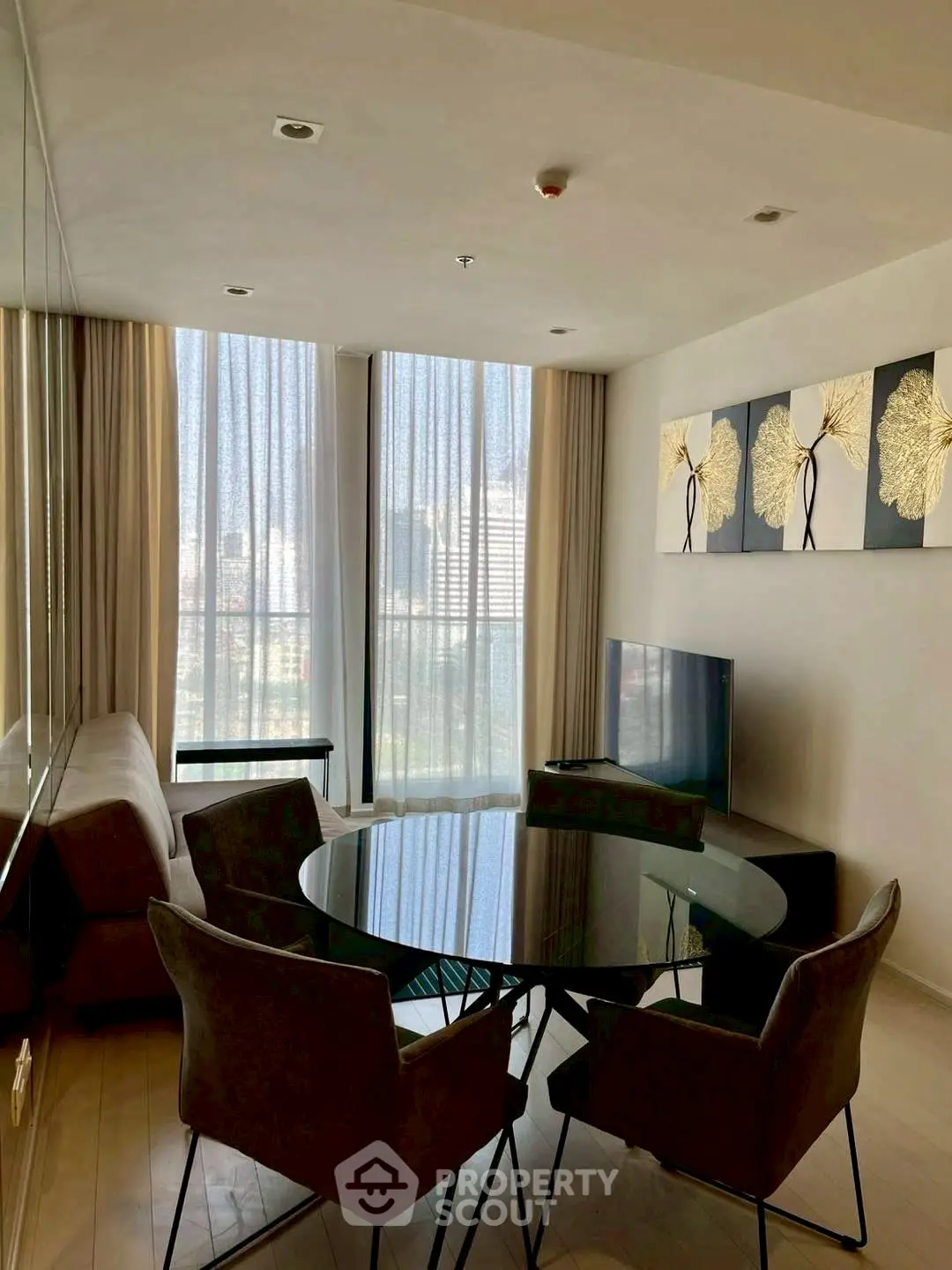 Modern living room with stylish decor and large windows offering natural light and city views.