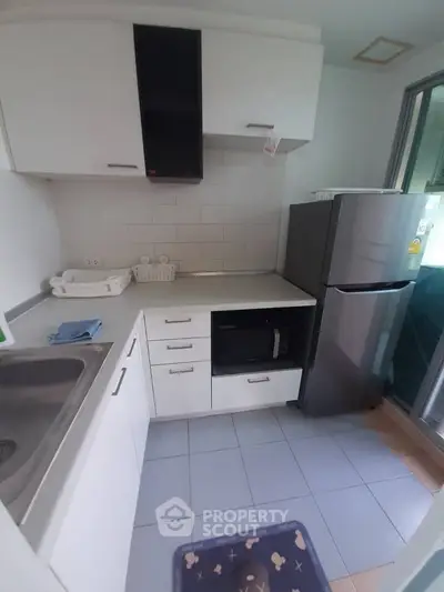 Modern compact kitchen with sleek appliances and ample storage space.