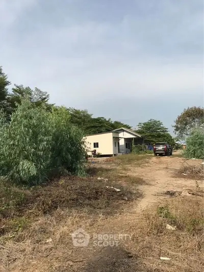 Charming rural property with lush greenery and a cozy house, perfect for serene living.