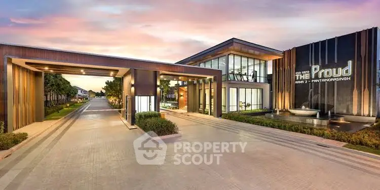 Modern luxury building entrance with sleek design and elegant landscaping at sunset.